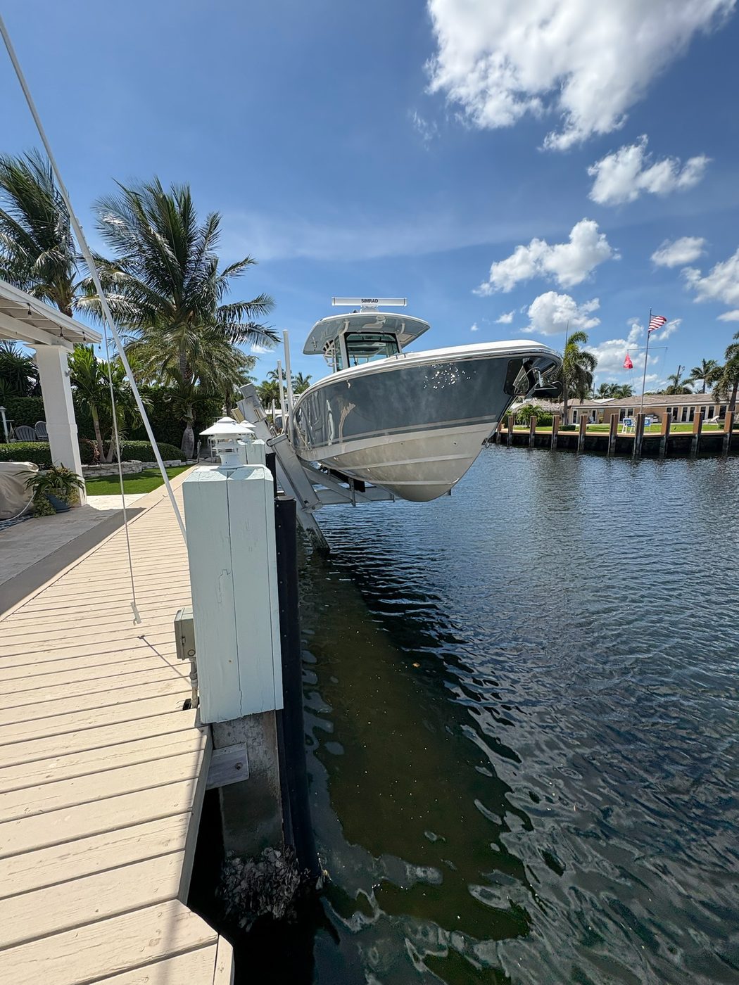 Center console boat on 4-post lift in Boca Raton canal