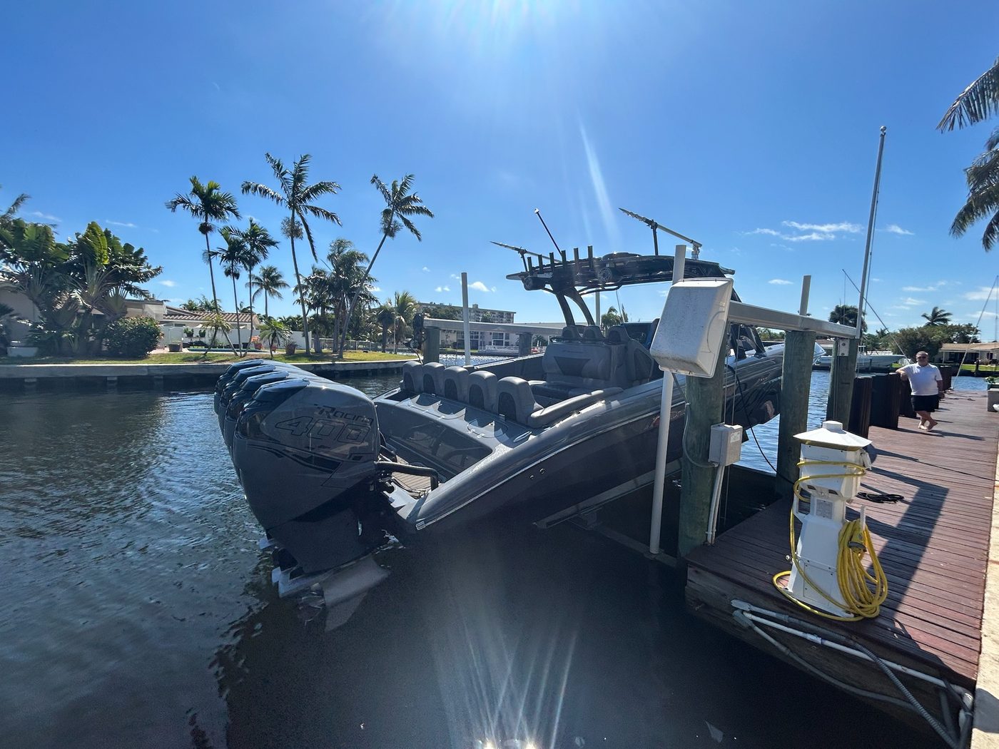 High-performance center console boat with quad outboards on boat lift in Boca Raton canal