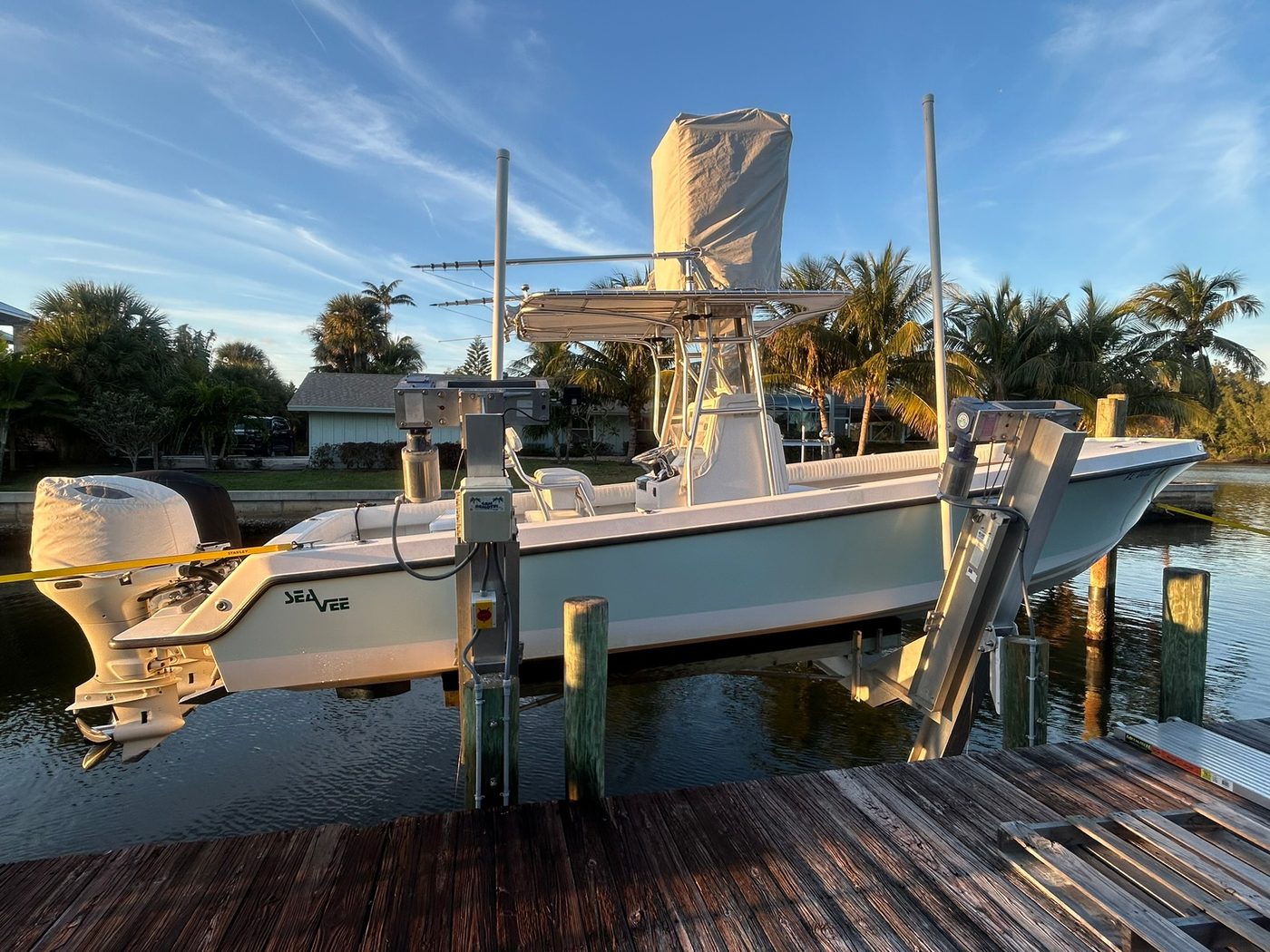 Well-maintained boat lift with sportfish boat at sunset
